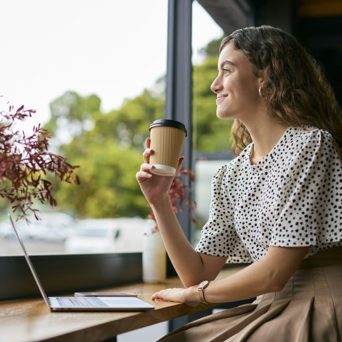 Young Businesswoman With Takeaway Coffee Working Sitting On Laptop In Coffee Shop Or Office